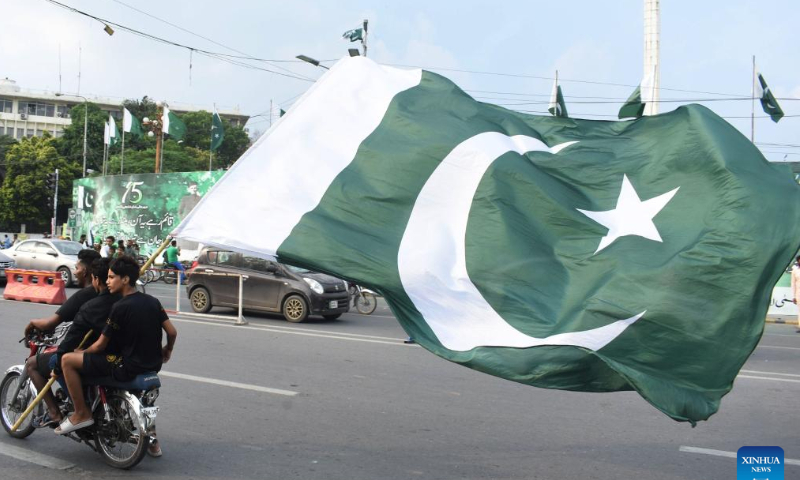 People hold a Pakistani national flag on a motorbike to celebrate the country's Independence Day in Lahore, Pakistan, on Aug. 14, 2022.  Photo: Xinhua