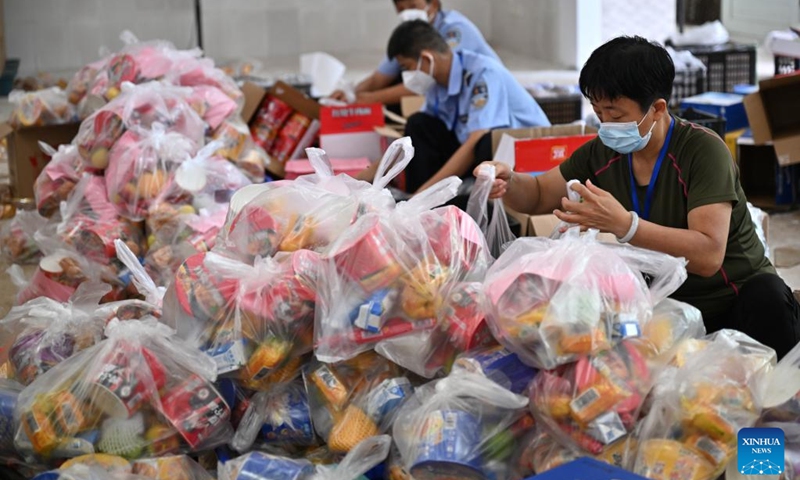 Staff members pack daily life supplies at a warehouse before delivery to local hotels where stranded tourists stay, in Sanya, south China's Hainan Province, Aug. 8, 2022. Task forces have been established to work around the clock to ensure daily life supplies for local residents and stranded tourists in an effort to fight against the new resurgence of COVID-19 in the city.((Photo: Xinhua)