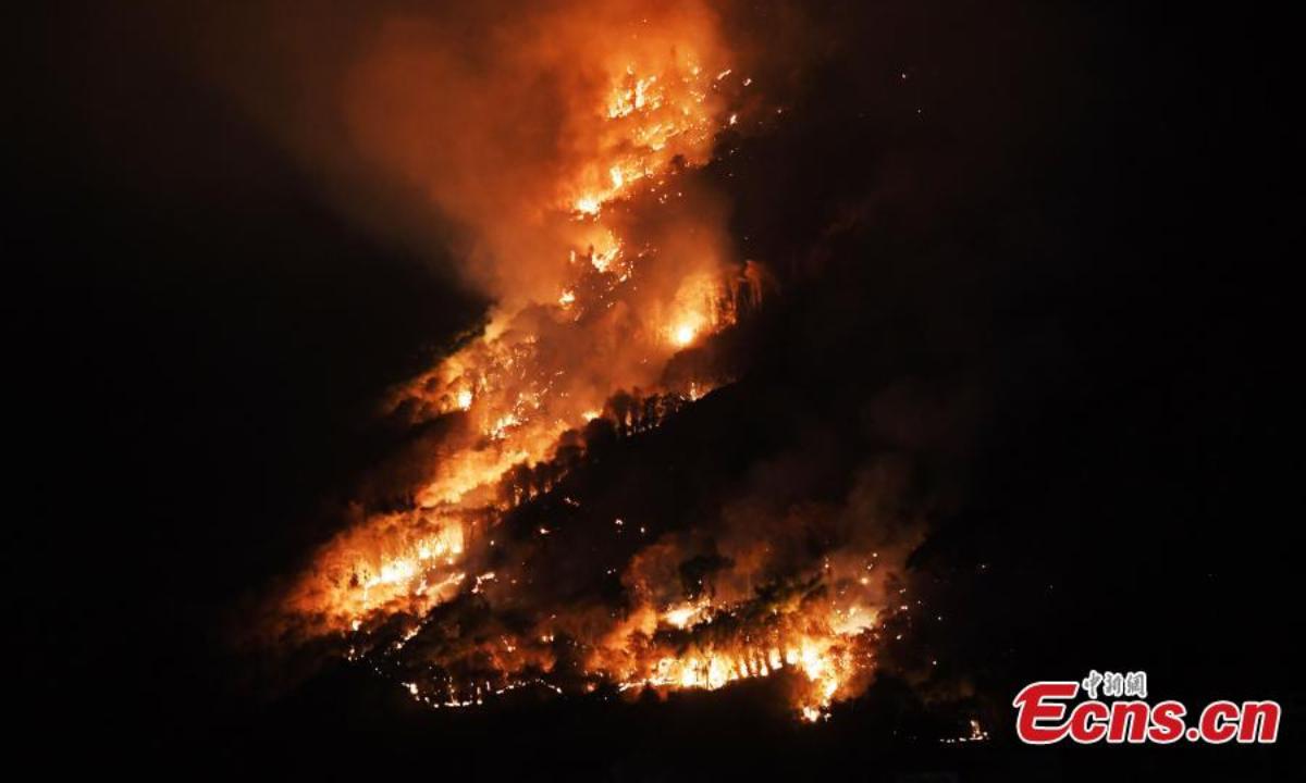 A massive fire burns on a mountain in Fuling district of Chongqing, Aug 19, 2022. Firefighters battle to contain the blaze. Photo:China News Service