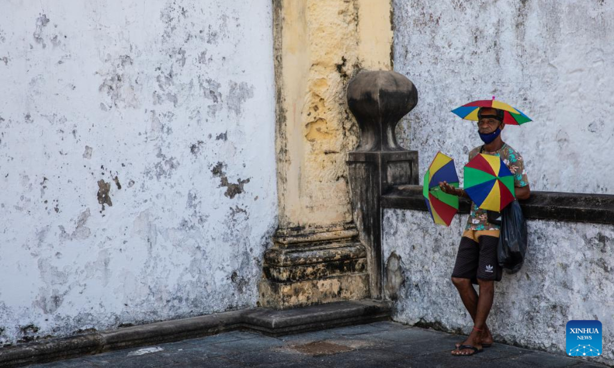 Um vendedor vende guarda-chuvas em Olinda, Brasil, em 11 de agosto de 2022.  O centro histórico da cidade de Olinda foi inscrito na Lista do Patrimônio Mundial da UNESCO em 1982.  Foto: Xinhua