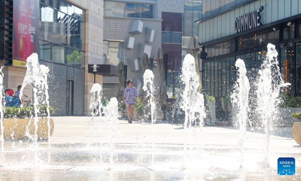 A citizen walks by a fountain amid high temperature in Minhang District of east China's Shanghai, July 10, 2022. Photo:Xinhua