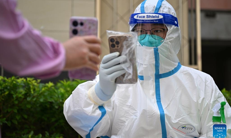 Zhou Shixun, a tourist-turned volunteer from Wuhan in central China's Hubei Province, registers nucleic acid test information at a residential area in Sanya, south China's Hainan Province, Aug. 9, 2022. Amid the latest resurgence of COVID-19 in Sanya, some tourists have joined local volunteers in combating the epidemic.(Photo: Xinhua)