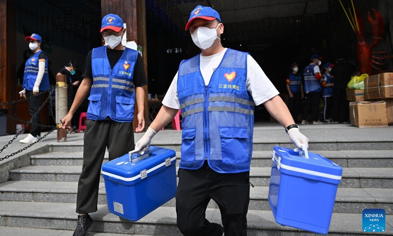 Chen Yi (R), a tourist-turned volunteer from Wenzhou in east China's Zhejiang Province, helps to carry medical supplies at a storehouse in Sanya, south China's Hainan Province, Aug. 9, 2022. Amid the latest resurgence of COVID-19 in Sanya, some tourists have joined local volunteers in combating the epidemic.(Photo: Xinhua)