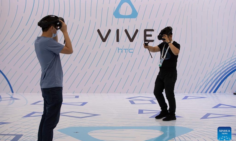 Staff members test devices at an exhibition booth during a media preview of the 2022 World 5G Convention in Harbin, capital of northeast China's Heilongjiang Province, Aug. 9, 2022. The 2022 World 5G Convention will be held here from August 10 to 12.(Photo: Xinhua)