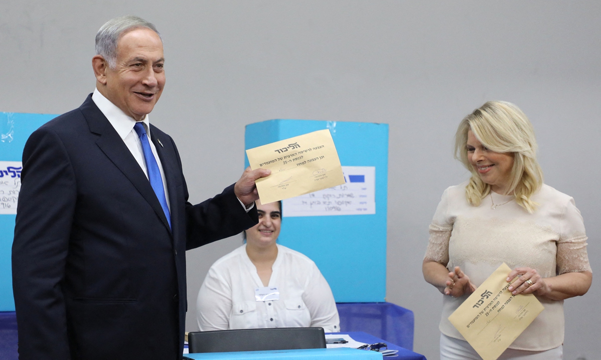 Israeli Likud party leader and former prime minister Benjamin Netanyahu votes with his wife Sara in a primary to fill out the party's Knesset (Israeli parliament) slate, in Tel Aviv on August 10, 2022. 