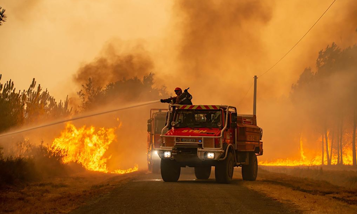Firefighters tackle a blaze near Hostens in southwestern France on August 10, 2022. Photo: VCG