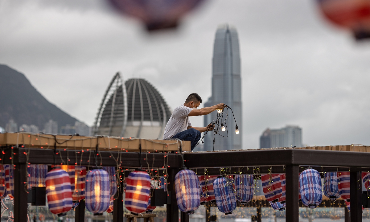 A worker sets up lanterns at a park in Hong Kong on June 18, 2022, to commemorate the 25th anniversary of Hong Kong's return to the motherland. Photo: IC