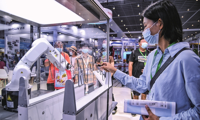 A visitor takes on a robot at an international equipment manufacturing expo in North China's Tianjin Municipality on August 11, 2022. New intelligent mechanical equipment is in focus at the expo, where more traditional exhibits such as high-end computer numerical control machines, industrial robots and fiber laser-cutting gear are being showcased. Photo: cnsphoto