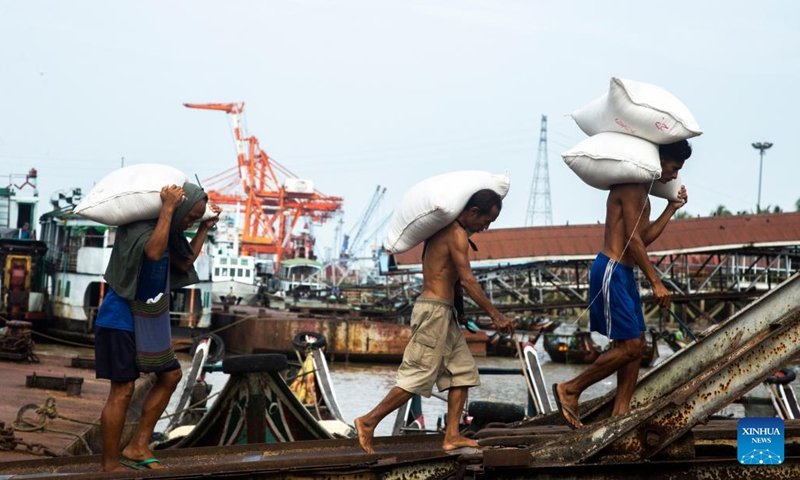 Workers carry bags of rice at a jetty in Yangon, Myanmar, on Aug. 11, 2022. Myanmar's agricultural export earnings decreased 1.25 percent to about 1.27 billion U.S. dollars year on year in the first four months of the present fiscal year (FY) 2022-2023, according to the Ministry of Commerce. The Southeast Asian country changed its fiscal year from the original October-September to April-March beginning this year.(Photo: Xinhua)