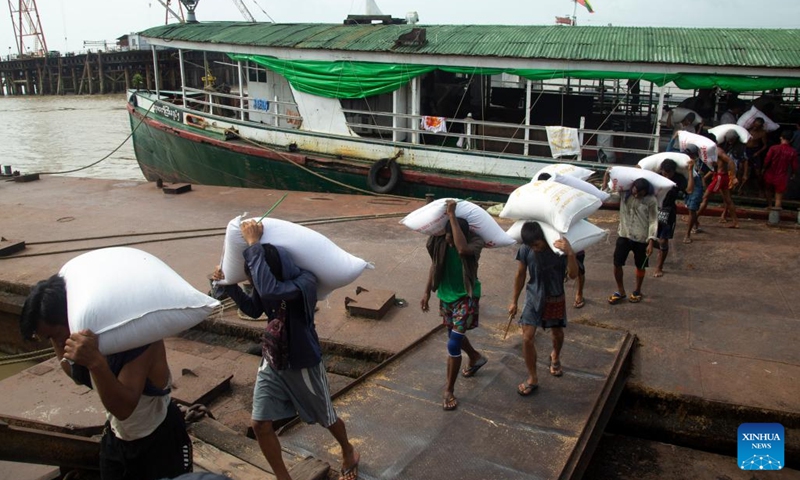 Workers unload bags of rice from a cargo boat at a jetty in Yangon, Myanmar on Aug. 11, 2022. Myanmar's agricultural export earnings decreased 1.25 percent to about 1.27 billion U.S. dollars year on year in the first four months of the present fiscal year (FY) 2022-2023, according to the Ministry of Commerce. The Southeast Asian country changed its fiscal year from the original October-September to April-March beginning this year.(Photo: Xinhua)