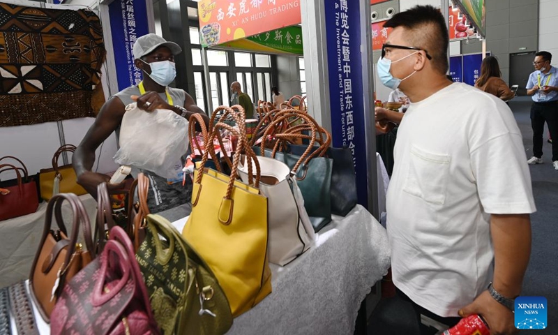 A visitor learns about leather products exhibited at the Mali booth during the sixth Silk Road International Exposition in Xi'an, northwest China's Shaanxi Province, Aug. 14, 2022. The Sixth Silk Road International Exposition opened Sunday in Xi'an, with deeper Belt and Road cooperation high on the agenda. (Xinhua/Li Yibo)