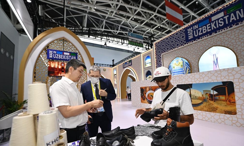 Visitors learn about specialties exhibited at the Uzbekistan booth during the sixth Silk Road International Exposition in Xi'an, northwest China's Shaanxi Province, Aug. 14, 2022. The Sixth Silk Road International Exposition opened Sunday in Xi'an, with deeper Belt and Road cooperation high on the agenda. (Xinhua/Li Yibo)