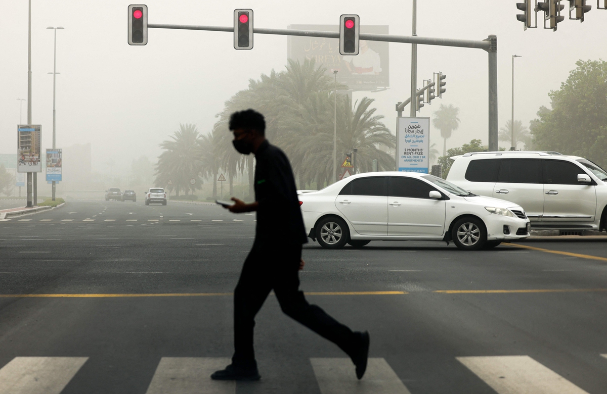 A man crosses a street during a sandstorm in the Gulf emirate of Dubai, on August 14, 2022. Large parts of the United Arab Emirates were hit by dust and sandstorms on August 14 as authorities urged caution on the roads and battened down for expected heavy rain. Photo: VCG