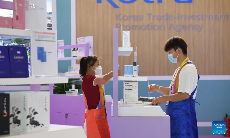 Staff members put products in place at the South Korea booth during the sixth Silk Road International Exposition in Xi'an, northwest China's Shaanxi Province, Aug. 14, 2022. The Sixth Silk Road International Exposition opened Sunday in Xi'an, with deeper Belt and Road cooperation high on the agenda. (Xinhua/Zou Jingyi)