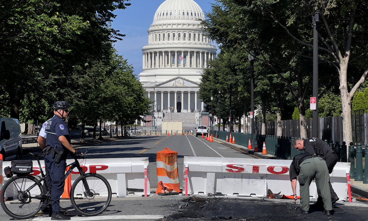 US Capitol Police Officers work near a police barricade on Capitol Hill in Washington, DC, on August 14, 2022. A man died early Sunday near the US Capitol building after driving his car into a barricade and firing shots into the air before turning his gun on himself, police said. Photo: AFP