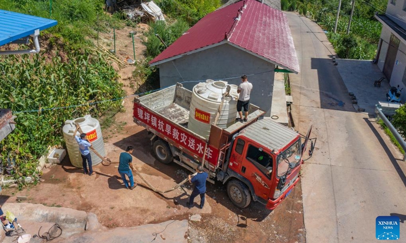 Aerial photo shows a vehicle transporting water to a water distribution point in Luoping Village of Wushan County, southwest China's Chongqing, Aug. 13, 2022. Persistent heatwaves have led to drought in parts of Wushan County. Authorities have increased efforts to better manage water resources for drought relief and ensure water supply for locals. (Xinhua/Huang Wei)
