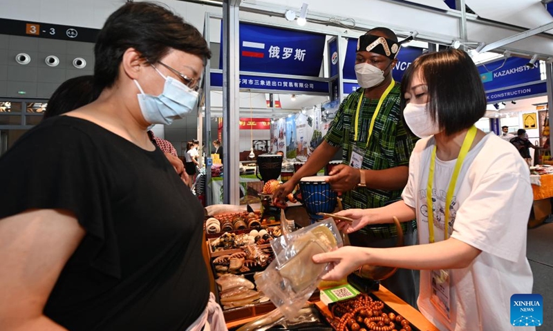 Visitors learn about specialties exhibited at the Ghana booth during the sixth Silk Road International Exposition in Xi'an, northwest China's Shaanxi Province, Aug. 14, 2022. The Sixth Silk Road International Exposition opened Sunday in Xi'an, with deeper Belt and Road cooperation high on the agenda. (Xinhua/Li Yibo)