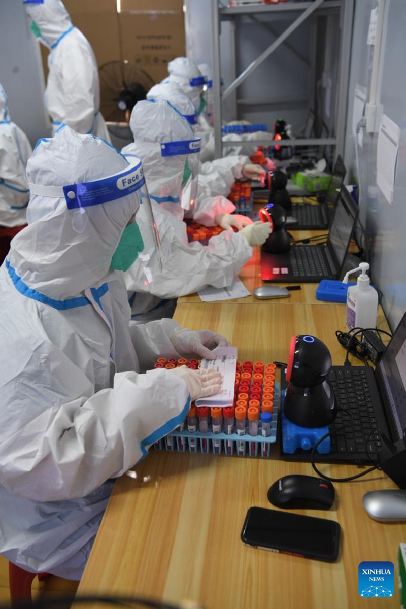 Medical workers scan the codes of nucleic acid samples at a testing lab in Sanya, south China's Hainan Province, Aug. 14, 2022. Sanya has optimized the processes of nucleic acid testing amid the latest COVID-19 resurgence. (Xinhua/Zhao Yingquan)