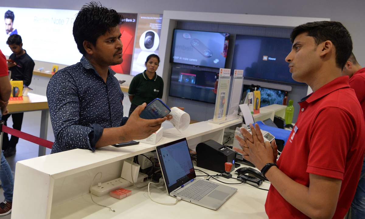 A salesman speaks with a customer at a Mi store in Gurgaon, India. Photo: VCG