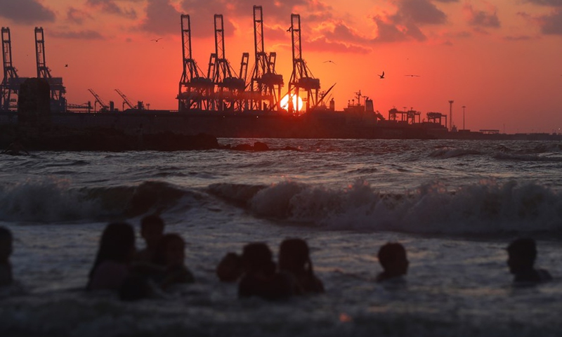 People enjoy the sunset at Alexandria port in Alexandria, Egypt on Aug. 13, 2022.(Photo: Xinhua)