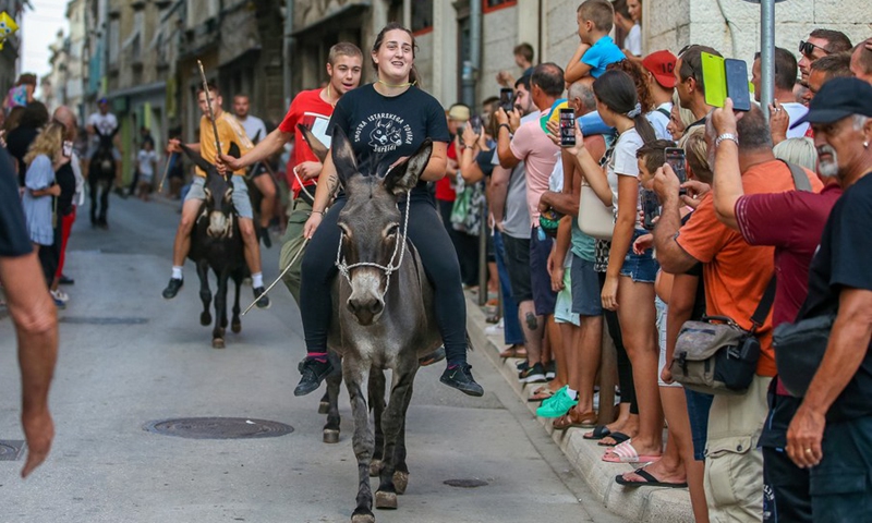 People take part in a donkey race in Vodnjan, Croatia, on Aug. 13, 2022.(Photo: Xinhua)