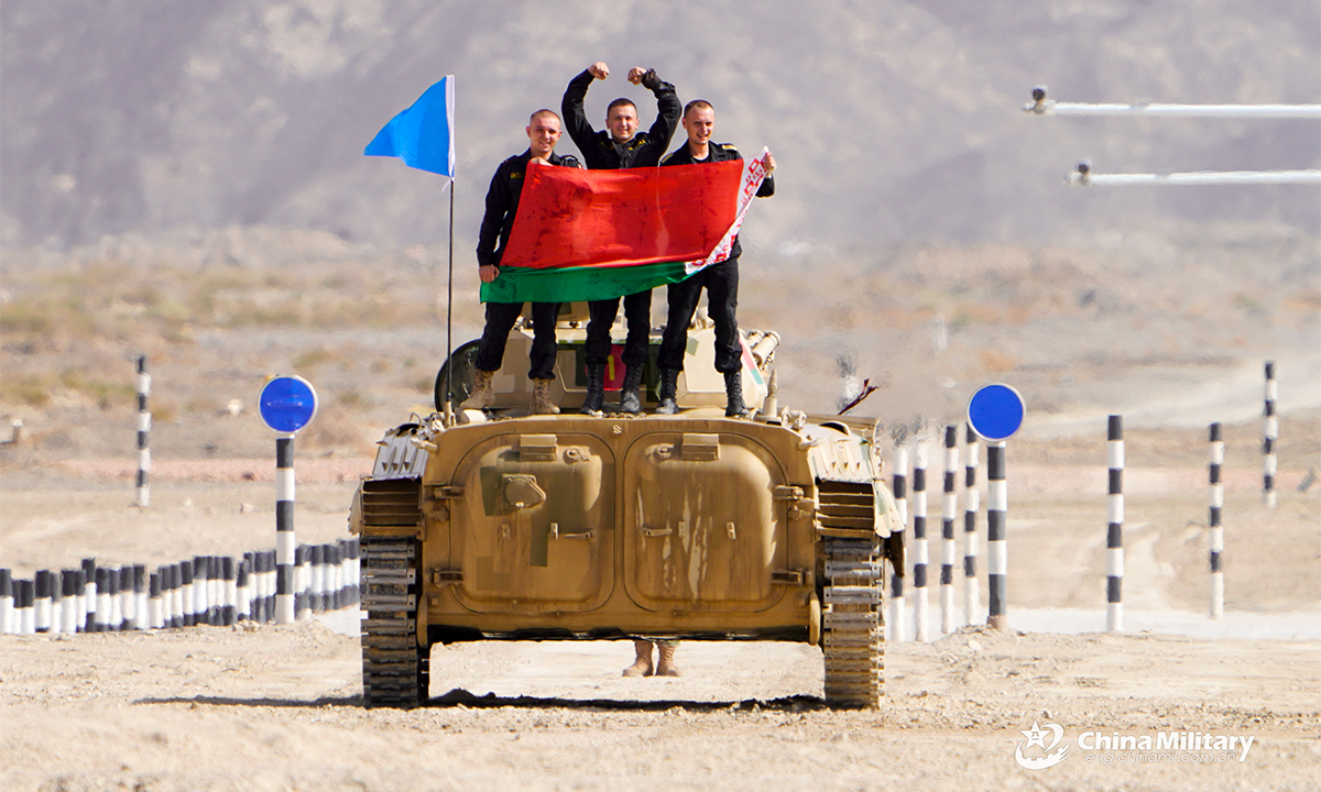 The infantry fighting vehicle crew of the Belarus team displays the national flag of Belarus after the first round of individual race of the Suvorov Onslaught contest in Korla, China's Xinjiang Uygur Autonomous Region, on August 14, 2022. The Suvorov Onslaught of the International Army Games 2022 (IAG 2022) kicked off on August 14 with participation of six teams from five countries, namely China, Russia, Belarus, Iran and Venezuela. (Photo by Lin Yong)