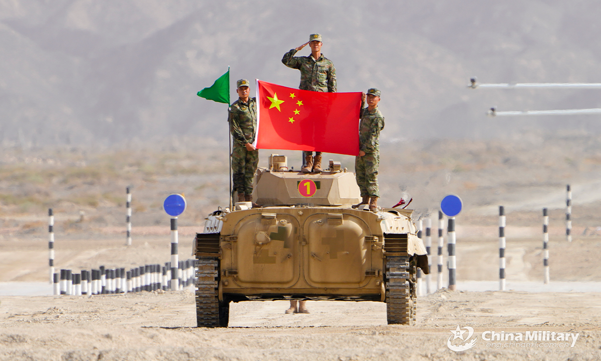 The infantry fighting vehicle crew of the Chinese team displays the national flag of China after the first round of individual race of the Suvorov Onslaught contest in Korla, China's Xinjiang Uygur Autonomous Region, on August 14, 2022. The Suvorov Onslaught of the International Army Games 2022 (IAG 2022) kicked off on August 14 with participation of six teams from five countries, namely China, Russia, Belarus, Iran and Venezuela. (Photo by Mo Pisen)