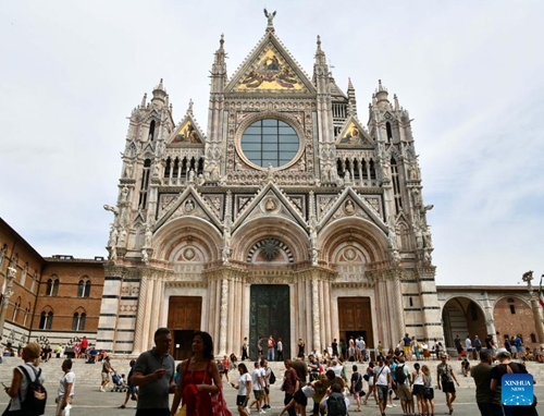 People gather around the Duomo di Siena in Siena, Italy, Aug. 15, 2022. Siena is famous for its medieval cityscape and the horse race Palio. The historic center of Siena was inscribed on the UNESCO World Heritage List in 1995.(Photo: Xinhua)