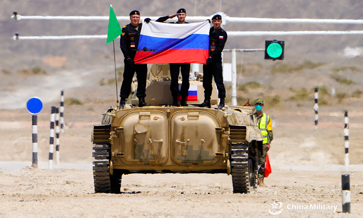 The infantry fighting vehicle crew of the Russian team displays the national flag of Russia after the first round of individual race of the Suvorov Onslaught contest in Korla, China's Xinjiang Uygur Autonomous Region, on August 14, 2022. The Suvorov Onslaught of the International Army Games 2022 (IAG 2022) kicked off on August 14 with participation of six teams from five countries, namely China, Russia, Belarus, Iran and Venezuela. (Photo by Lin Yong)