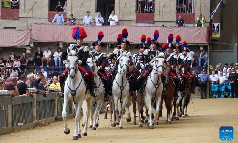 Italian Carabinieri perform before the suspension of the horse race Palio in Siena, Italy, Aug. 16, 2022. The horse race Palio has been postponed to Aug. 17 due to the rain. The historical horse race Palio is held again this year after a two-year pause because of the COVID-19 pandemic. (Xinhua/Jin Mamengni)