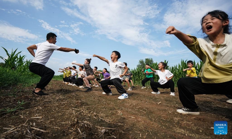 Liu Long teaches children Chinese martial arts in Liuzhuang Village of Pizhou City, east China's Jiangsu Province, Aug. 16, 2022. Liu Long, 35, is a Chinese martial arts enthusiast. He found that his three children were also interested in martial arts and often imitated the action of him when he was practicing, so he began to take the three children to do martial arts training. Local villagers also sent their children to learn martial arts from Liu.(Photo: Xinhua)