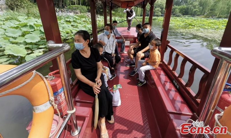 Tourists take boat to appreciate lotus flowers at Zizhuyuan (Purple Bamboo)Park in Beijing, Aug. 17, 2022. Visitors can enjoy a close look at the flowers by riding a boat in the ponds during the summer season. (Photo: China News Service/Zhao Jun)