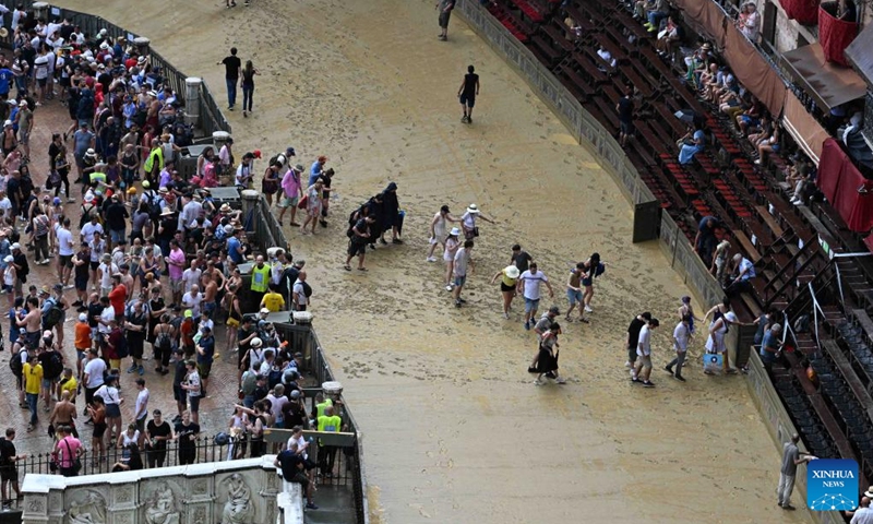Spectators leave after the suspension of the horse race Palio in Siena, Italy, Aug. 16, 2022. The horse race Palio has been postponed to Aug. 17 due to the rain. The historical horse race Palio is held again this year after a two-year pause because of the COVID-19 pandemic. (Photo by Alberto Lingria/Xinhua)