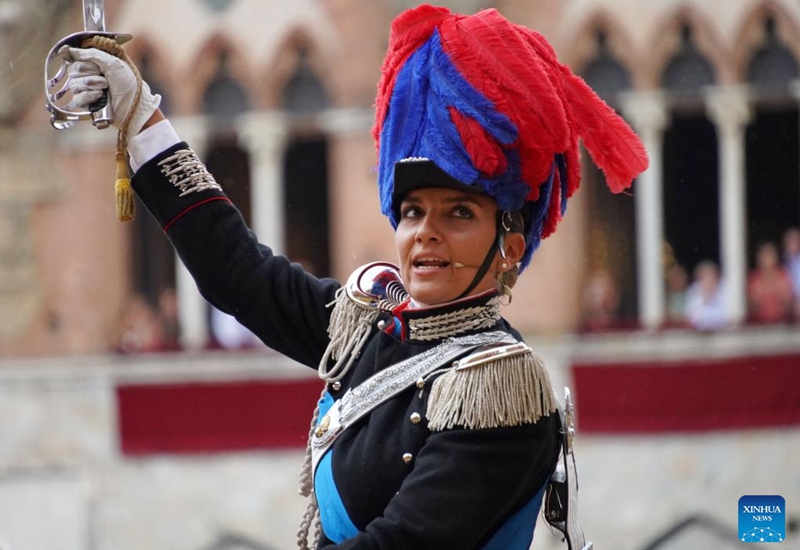 An Italian Carabinieri performs before the suspension of the horse race Palio in Siena, Italy, Aug. 16, 2022. The horse race Palio has been postponed to Aug. 17 due to the rain. The historical horse race Palio is held again this year after a two-year pause because of the COVID-19 pandemic. (Xinhua/Jin Mamengni)