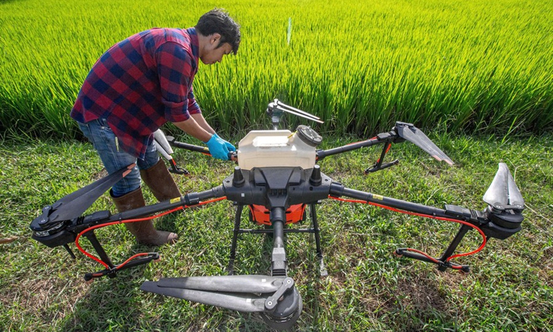 A Thai farmer checks a DJI agricultural drone in Roi Et, Thailand, on Aug. 1, 2022.(Photo: Xinhua)