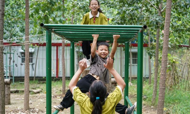 Liu Long's daughters Liu Yiting, Liu Yidian (up) and son Liu Yixing (C) have a break during training in Liuzhuang Village of Pizhou City, east China's Jiangsu Province, Aug. 16, 2022. Liu Long, 35, is a Chinese martial arts enthusiast. He found that his three children were also interested in martial arts and often imitated the action of him when he was practicing, so he began to take the three children to do martial arts training.(Photo: Xinhua)
