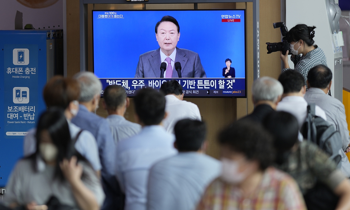 People watch a live television broadcast of South Korean President Yoon Suk-yeol's press conference that mark his first 100 day in office, at Seoul Railway Station on August 17, 2022. Photo: VCG