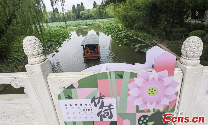 2022年8月17日，游客乘船在北京紫竹园（紫竹）公园赏荷。夏季，游客可以在池塘中乘船近距离观赏荷花。  （图片：中新社/赵军）