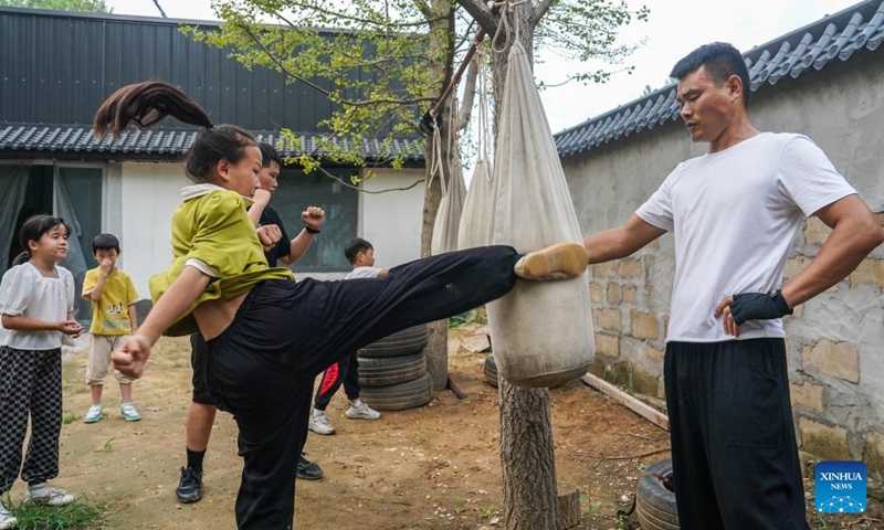 Liu Long (R) instructs his daughter Liu Yidian to practise Chinese martial arts in Liuzhuang Village of Pizhou City, east China's Jiangsu Province, Aug. 16, 2022. Liu Long, 35, is a Chinese martial arts enthusiast. He found that his three children were also interested in martial arts and often imitated the action of him when he was practicing, so he began to take the three children to do martial arts training.(Photo: Xinhua)