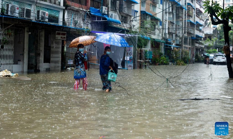People wade through a flooded street after heavy rains in Yangon, Myanmar, Aug. 17, 2022.(Photo: Xinhua)