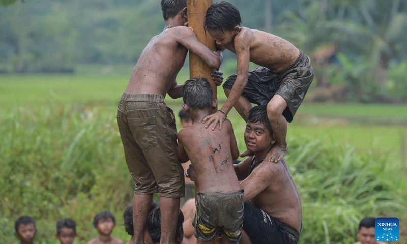 Children participate in a slippery pole climbing game to celebrate the 77th Independence Day at Rabak village, Bogor district of West Java province, Indonesia, Aug. 17, 2022.(Photo: Xinhua)
