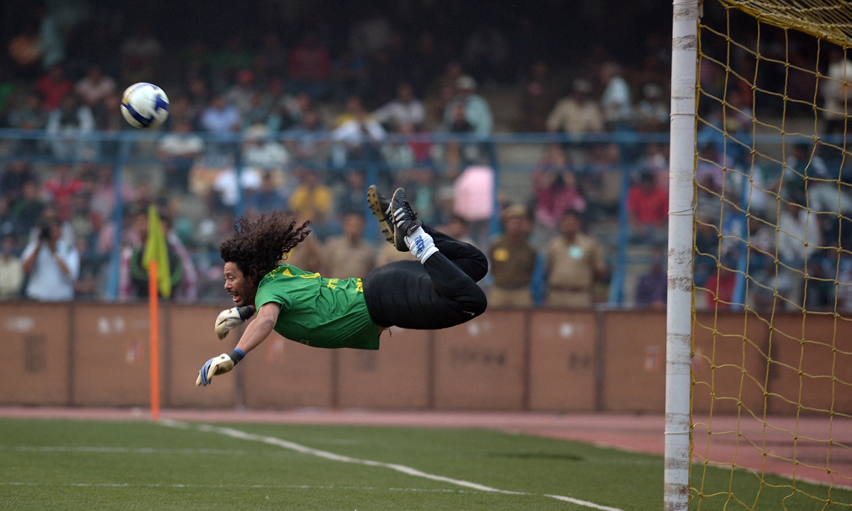Former Colombian goolkeeper Rene Higuita saves a goal during an exhibition match between the Brazilian Masters and Indian All Stars in Kolkata, India on December 8, 2012. Photo: AFP