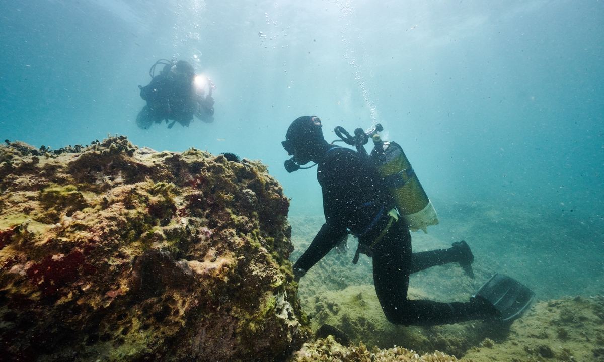 A diver of a special unit of the Guardia di Finanza, Italy's financial police, monitors an area where rocks have been defaced by the indiscriminate and illegal harvesting of date mussels, in the sea off the coast of Monopoli in the Puglia region, Italy on July 28, 2022. Photo: AFP