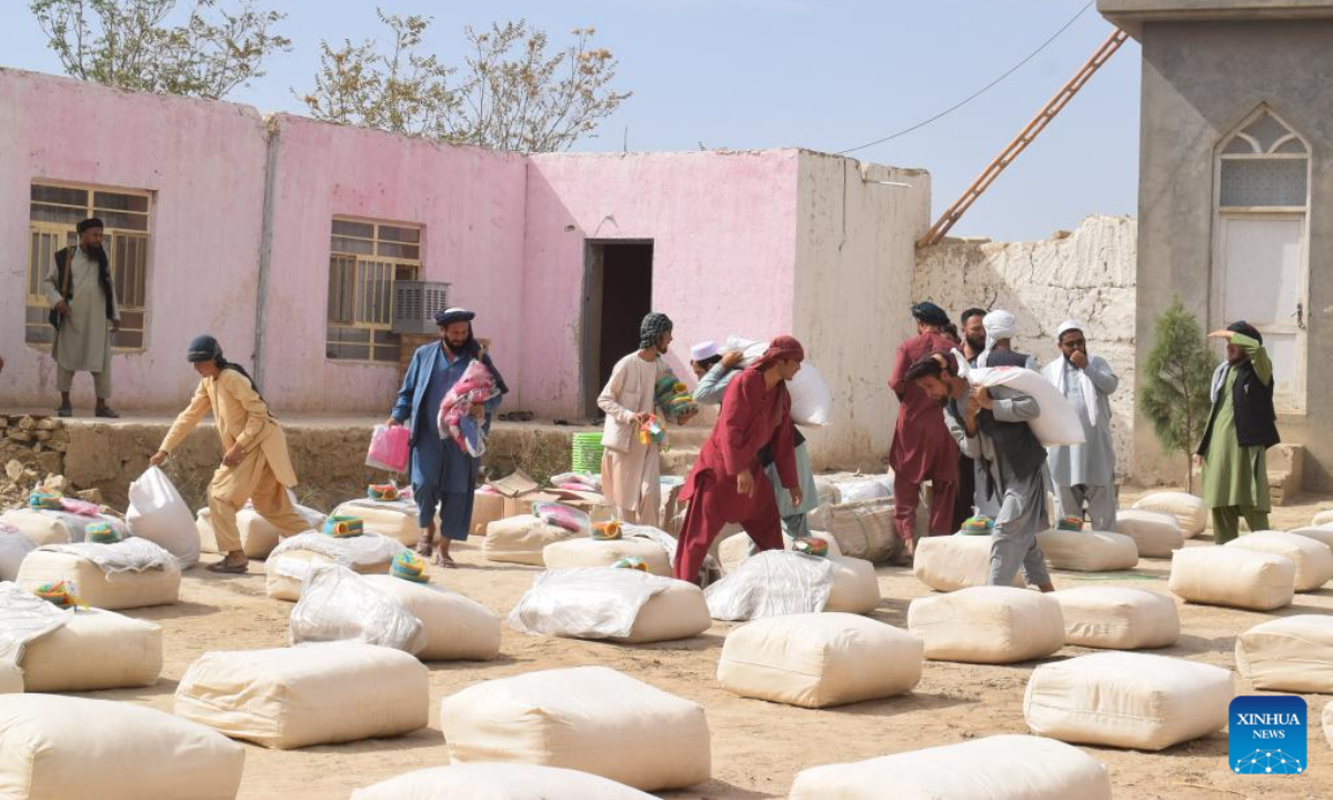 Afghan people carry China-donated relief supplies in Jawzjan province, Afghanistan, Aug. 24, 2022. A total of 75 families who lost their houses in a recent fire that occurred in Faizabad district of the northern Jawzjan province have received humanitarian assistance donated by China, a provincial officer said Thursday. Photo:Xinhua