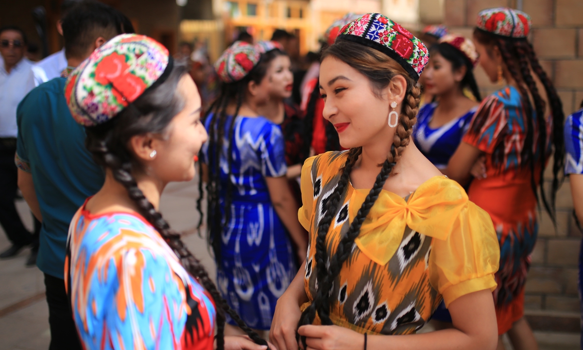 Women in traditional garb chat during a break from a group dance during the Corban Festival in Hotan. Photo: Liu Xin, Fan Lingzhi/GT