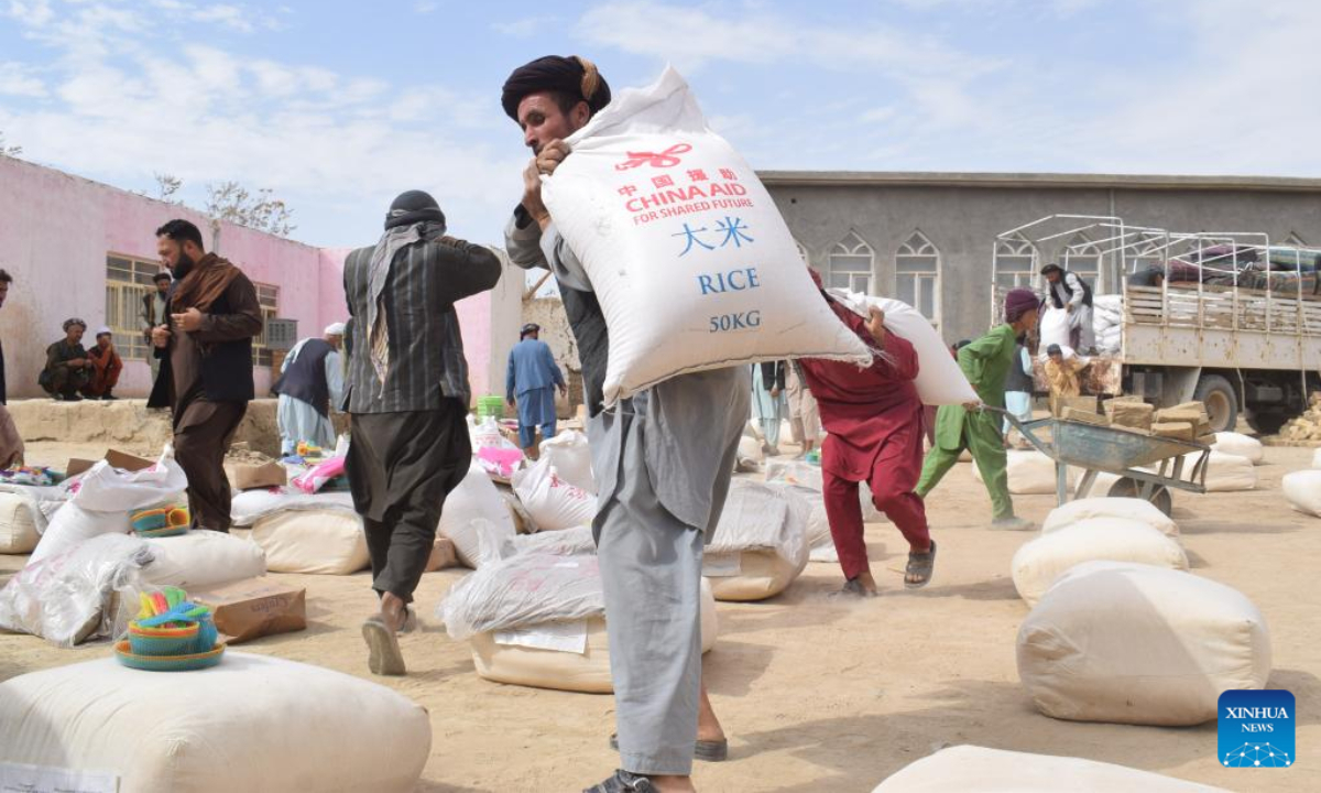 Afghan people carry China-donated relief supplies in Jawzjan province, Afghanistan, Aug. 24, 2022. A total of 75 families who lost their houses in a recent fire that occurred in Faizabad district of the northern Jawzjan province have received humanitarian assistance donated by China, a provincial officer said Thursday. Photo:Xinhua