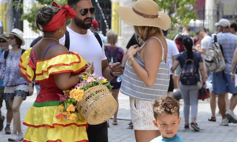 Tourists talk with a Cuban woman in the area of Old Havana, in Havana, capital of Cuba, Sept. 7, 2018.Photo:Xinhua