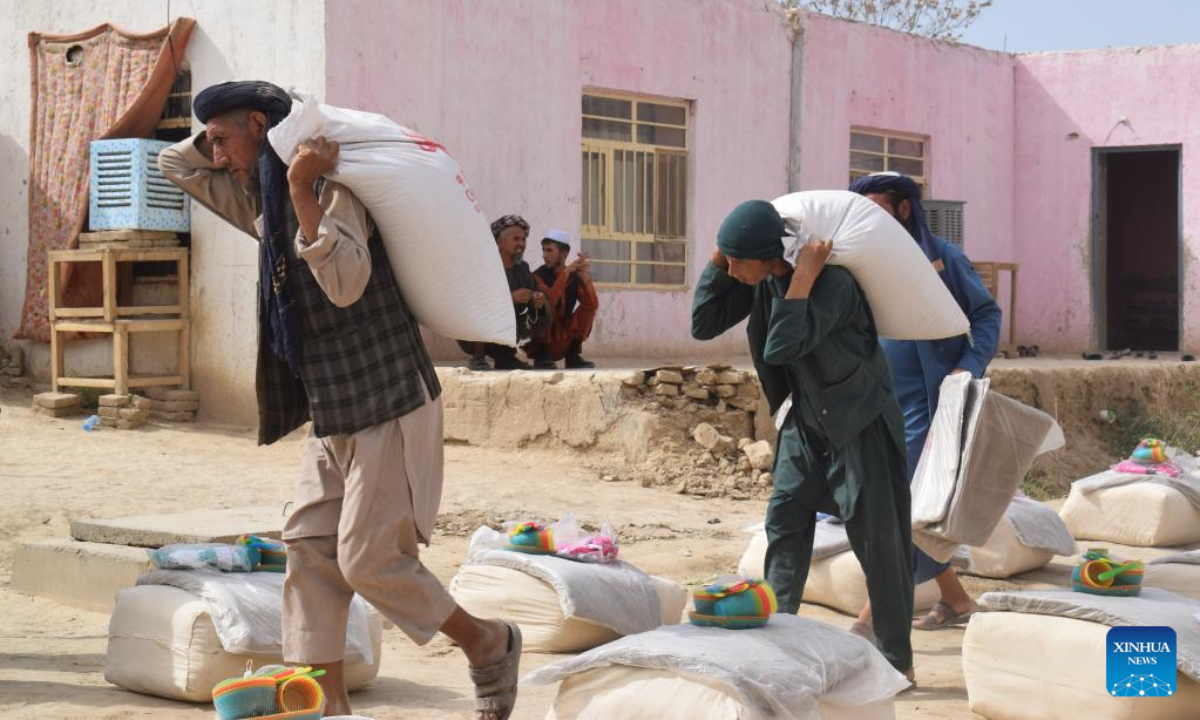Afghan people carry China-donated relief supplies in Jawzjan province, Afghanistan, Aug. 24, 2022. A total of 75 families who lost their houses in a recent fire that occurred in Faizabad district of the northern Jawzjan province have received humanitarian assistance donated by China, a provincial officer said Thursday. Photo:Xinhua