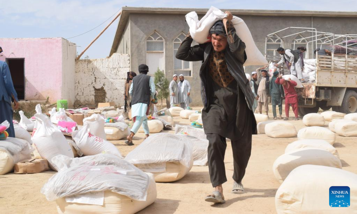 Afghan people carry China-donated relief supplies in Jawzjan province, Afghanistan, Aug. 24, 2022. A total of 75 families who lost their houses in a recent fire that occurred in Faizabad district of the northern Jawzjan province have received humanitarian assistance donated by China, a provincial officer said Thursday. Photo:Xinhua