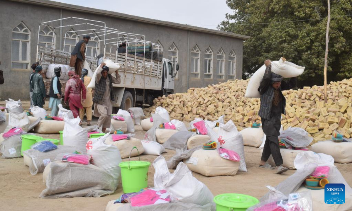 Afghan people carry China-donated relief supplies in Jawzjan province, Afghanistan, Aug. 24, 2022. A total of 75 families who lost their houses in a recent fire that occurred in Faizabad district of the northern Jawzjan province have received humanitarian assistance donated by China, a provincial officer said Thursday. Photo:Xinhua